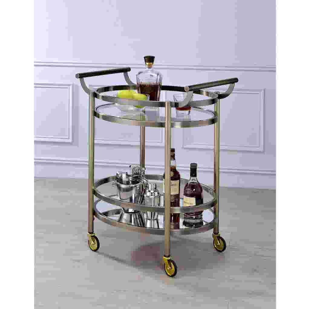 A serving cart with bottles and glasses on it, placed in a room.